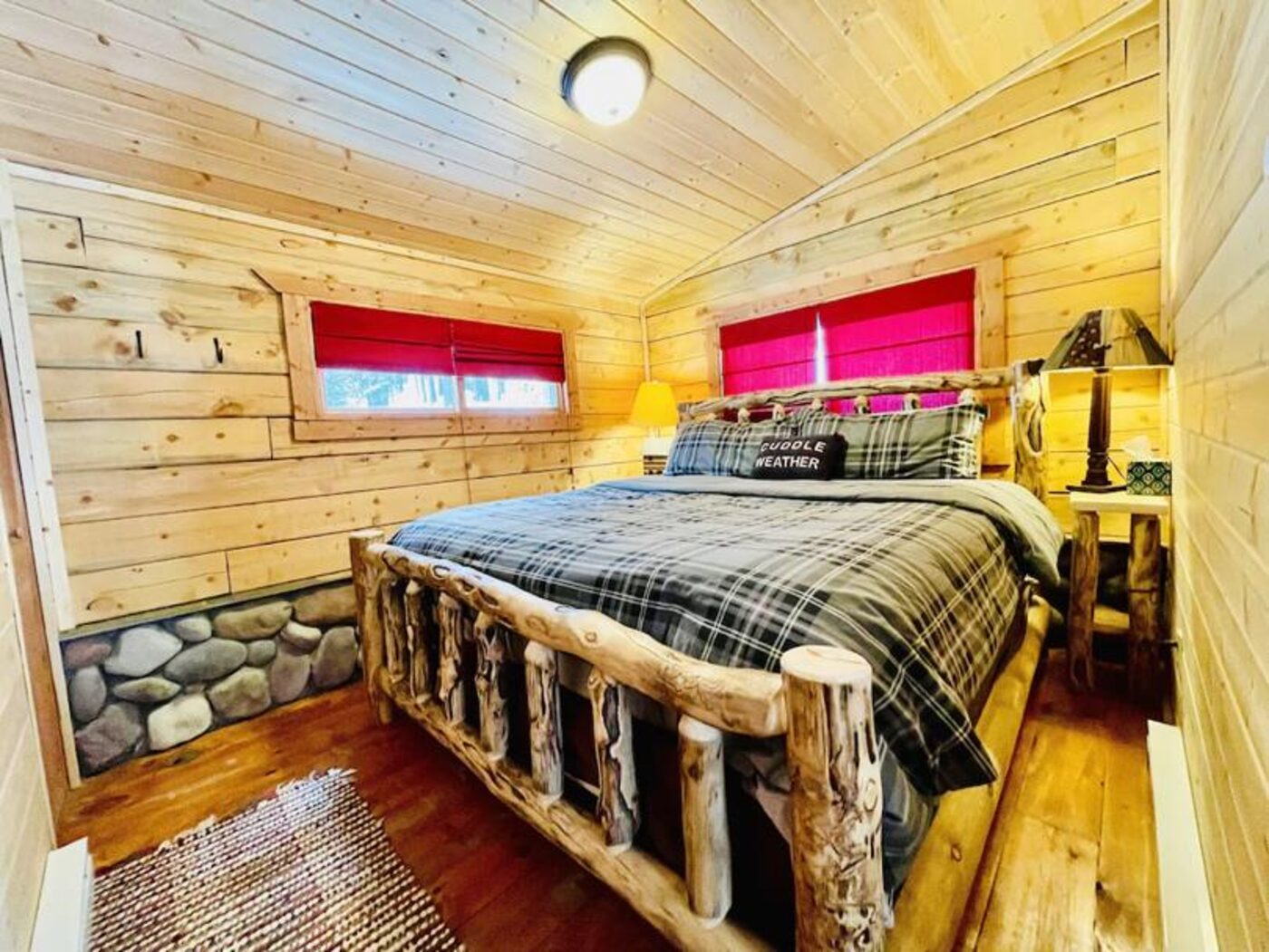 Loft bedroom with log bed frame and plaid bedding