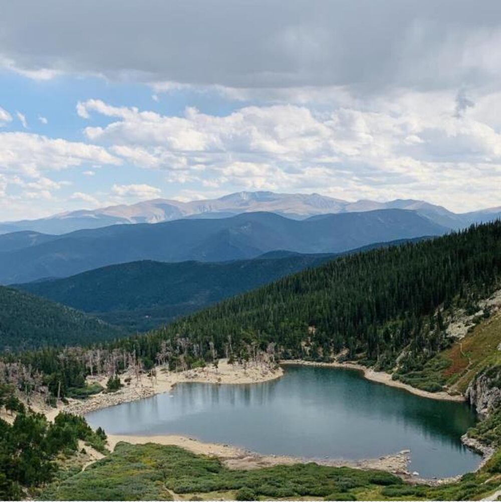 St. Mary's Glacier alpine lake surrounded by pine forest and mountains